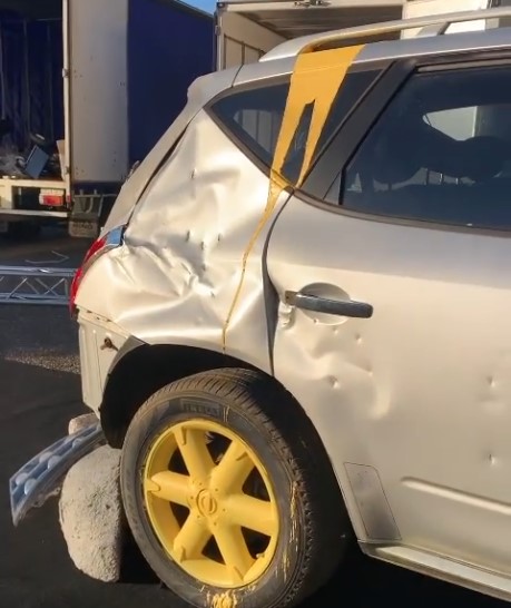 Wrecked silver car with yellow wheels and graphics used as a promotional prop by Mega 3D Signs